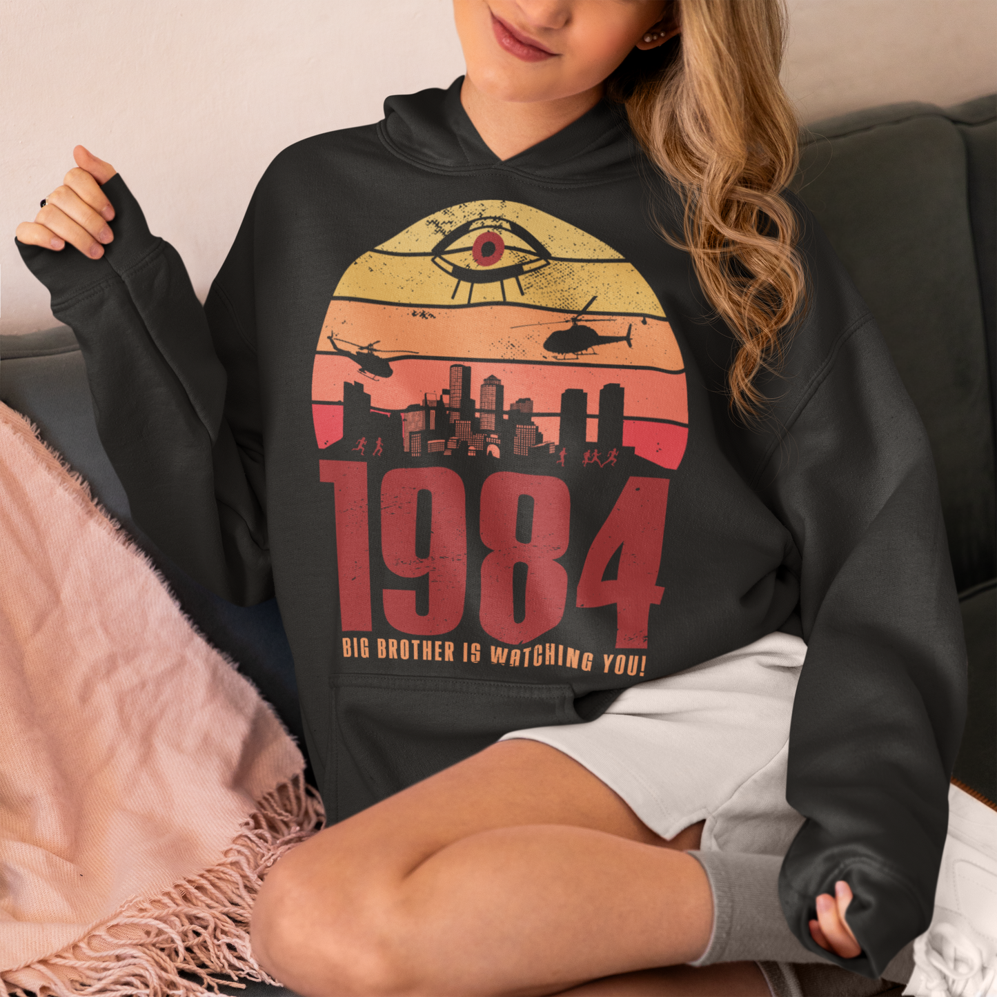 Introducing our George Orwell 1984 Hoodie with a bold "Big Brother is Watching" design! If you're a fan of Orwell's classic dystopian novel or just love thought-provoking literary references, this shirt is for you. The design features the iconic phrase "Big Brother is Watching" in small, bold letters, set against a stark sunset background. The lettering has a slightly distressed, vintage look, giving the shirt a cool, edgy vibe.