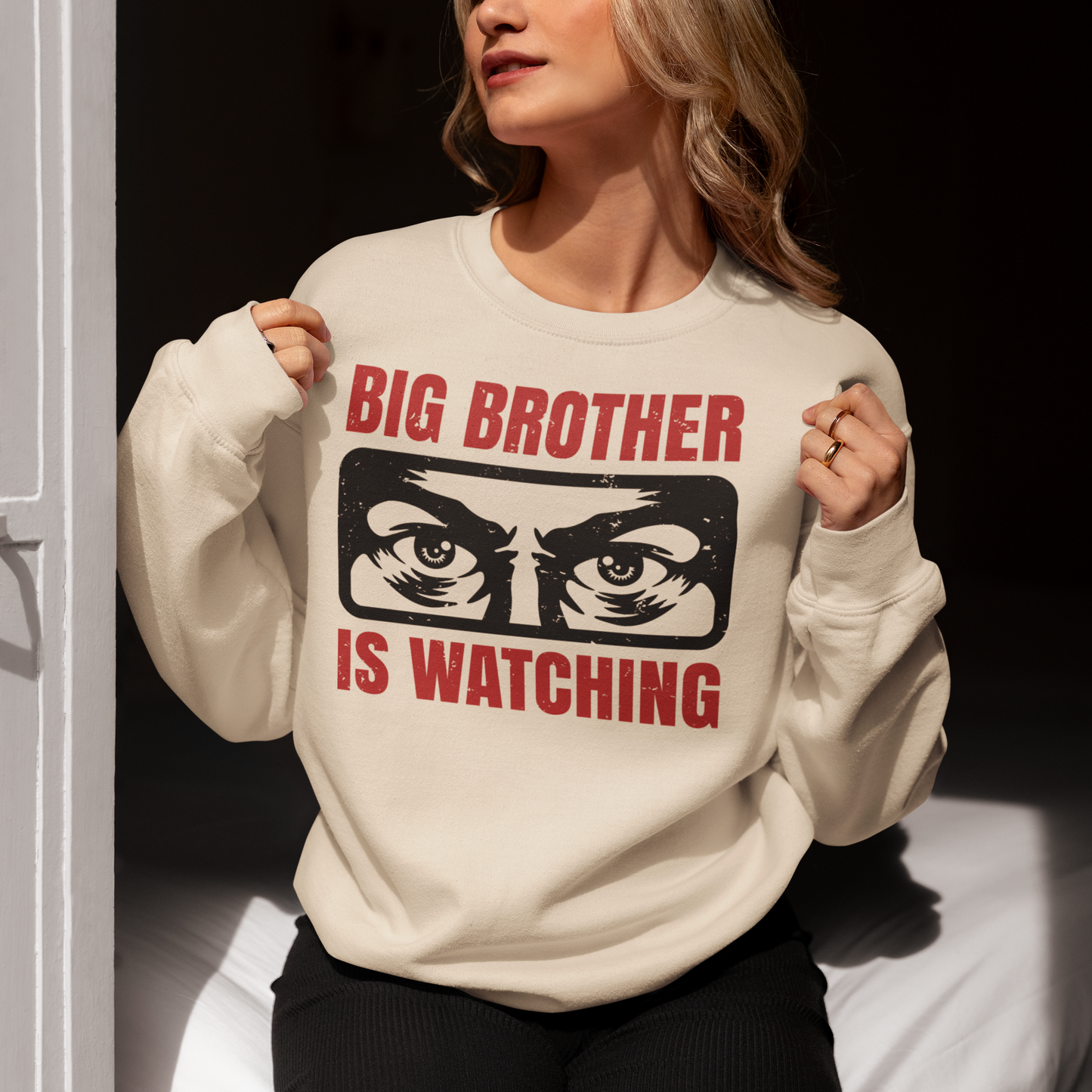 Introducing our captivating sweatshirt, featuring a mesmerizing design that will capture attention wherever you go. This unique sweatshirt showcases a pair of piercing eyes, seemingly observing your every move, accompanied by the thought-provoking text: "BIG BROTHER IS WATCHING YOU."