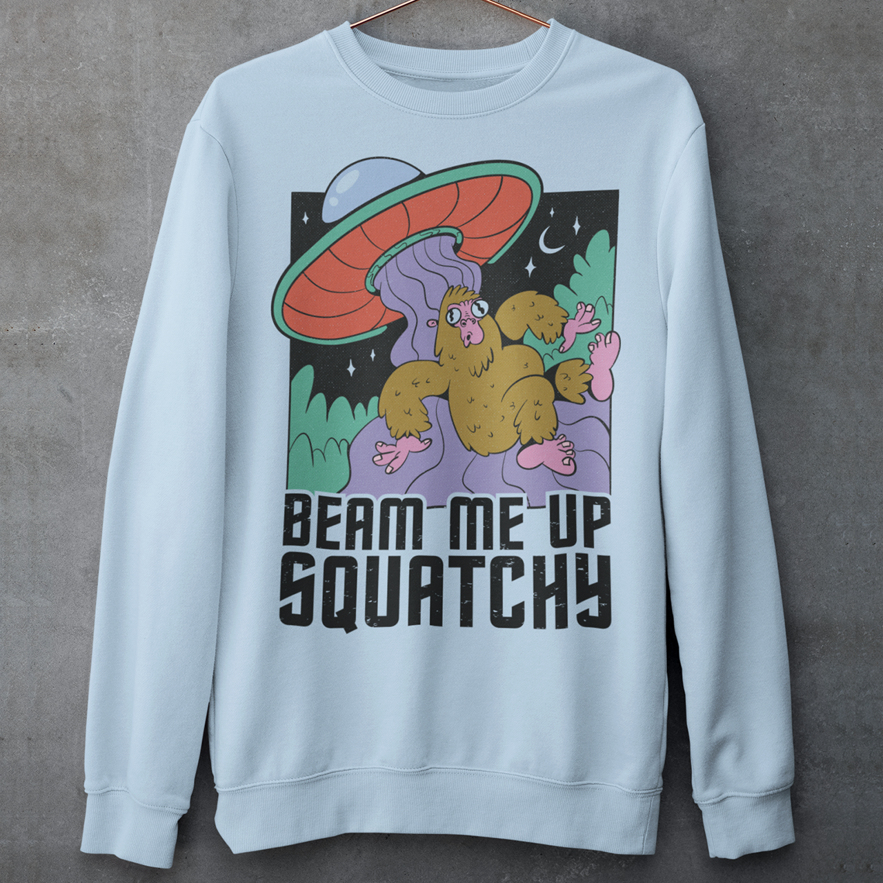 Light Blue sweatshirt of a sasquatch being abducted by a UFO with text BEAM ME UP SQUATCHY.