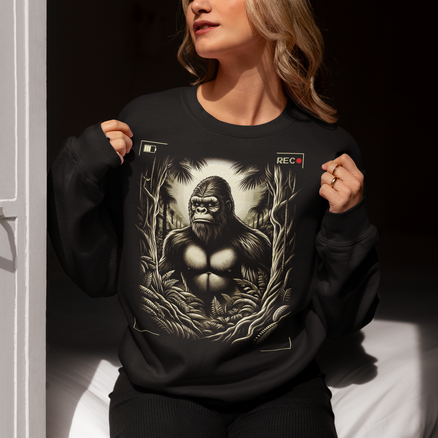 This sweatshirt features a captivating and mysterious scene: Bigfoot, the legendary creature of folklore, is depicted peeking through dense, shadowy trees. The design captures the thrill of a rare sighting with intricate details, from the leaves rustling in the breeze to Bigfoot's curious expression.