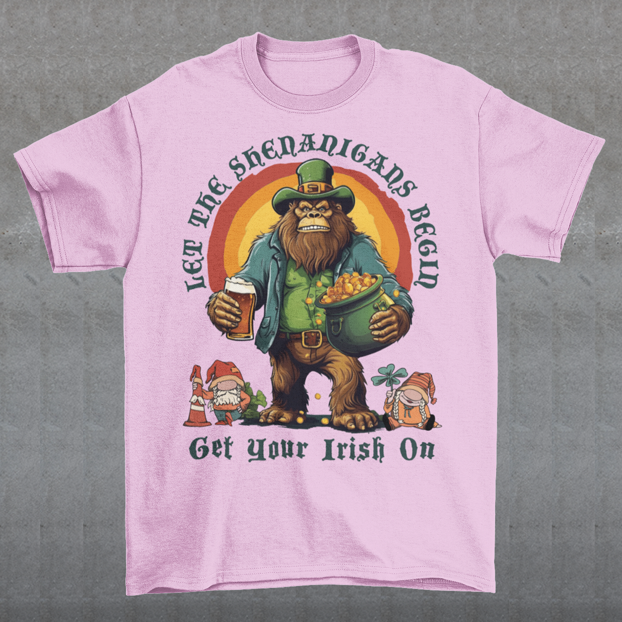 Get ready to celebrate St. Patrick's Day in style with our hilarious and festive Bigfoot-themed t-shirt! This shirt features everyone's favorite cryptid, Bigfoot, dressed in full leprechaun attire, complete with a green hat and shamrock-adorned vest. Bigfoot is depicted holding a frothy beer in one hand and a gleaming pot of gold in the other, ready to join in the festivities. Above this whimsical scene, bold text declares, "LET THE SHENANIGANS BEGIN."