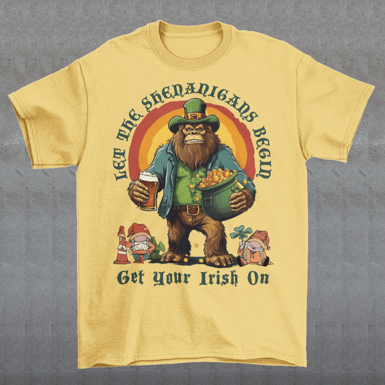 Get ready to celebrate St. Patrick's Day in style with our hilarious and festive Bigfoot-themed t-shirt! This shirt features everyone's favorite cryptid, Bigfoot, dressed in full leprechaun attire, complete with a green hat and shamrock-adorned vest. Bigfoot is depicted holding a frothy beer in one hand and a gleaming pot of gold in the other, ready to join in the festivities. Above this whimsical scene, bold text declares, "LET THE SHENANIGANS BEGIN."