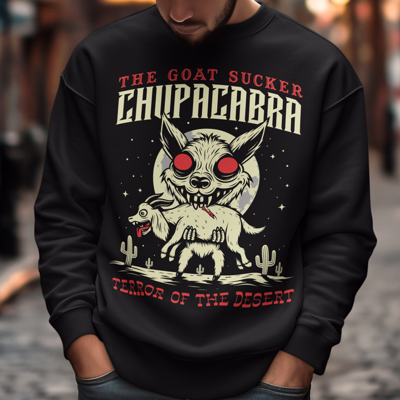 Black sweatshirt of a chupacabra sucking on a goat in the desert with text above THE GOAT SUCKER CHUPACABRA ang text below TERROR OF THE DESERT.