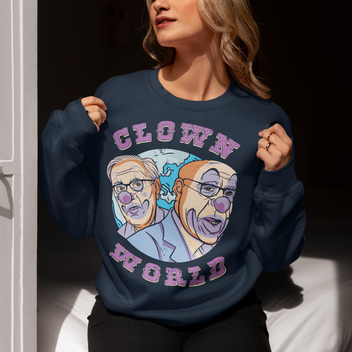 This bold and colorful sweatshirt features a playful design that captures the absurdity and chaos of our modern times. With a cast of wacky characters, including clowns, jesters, and other oddball creatures, this shirt is perfect for anyone who loves a good laugh or wants to show their disdain for the status quo.