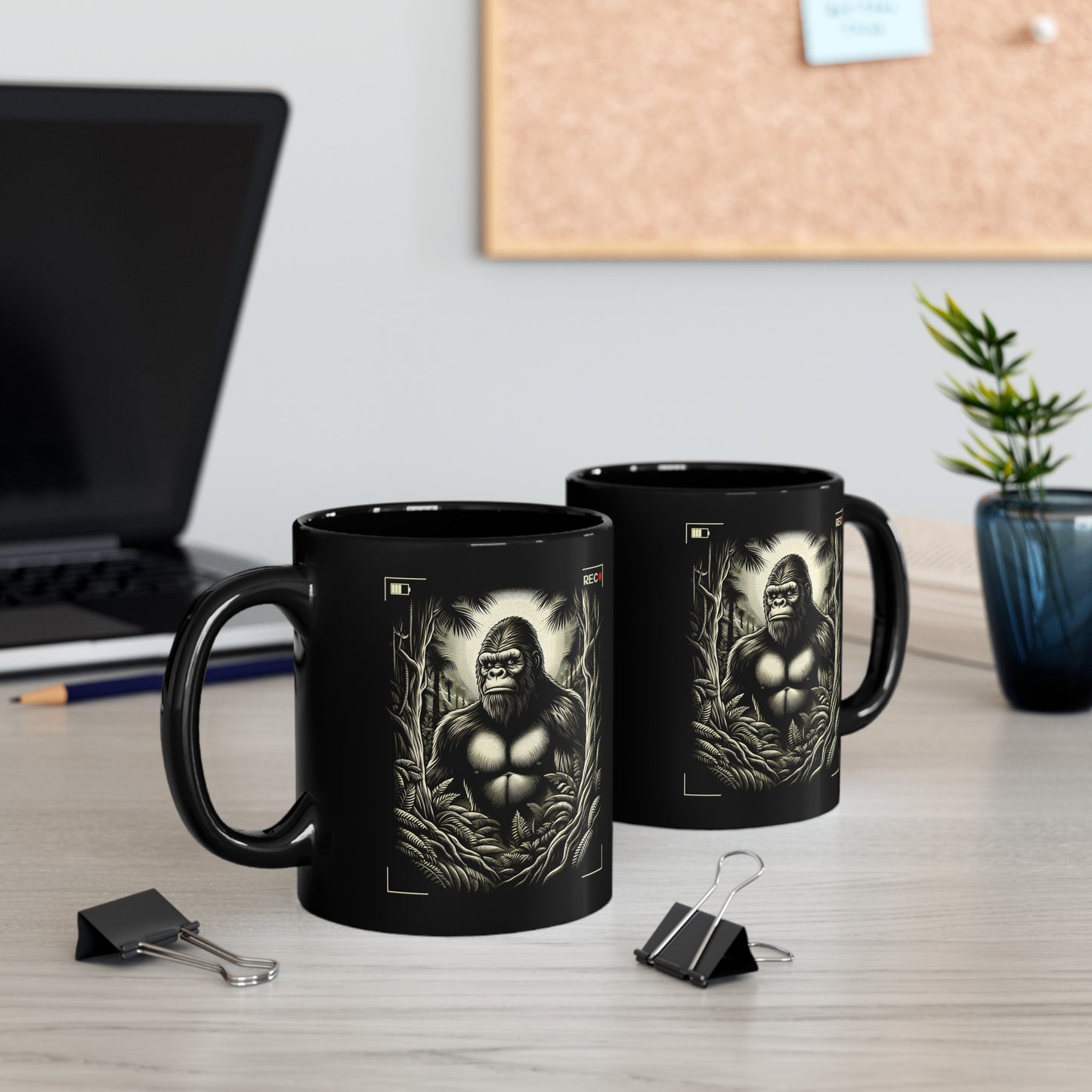 Black mug of Bigfoot being recorded looking through the trees.