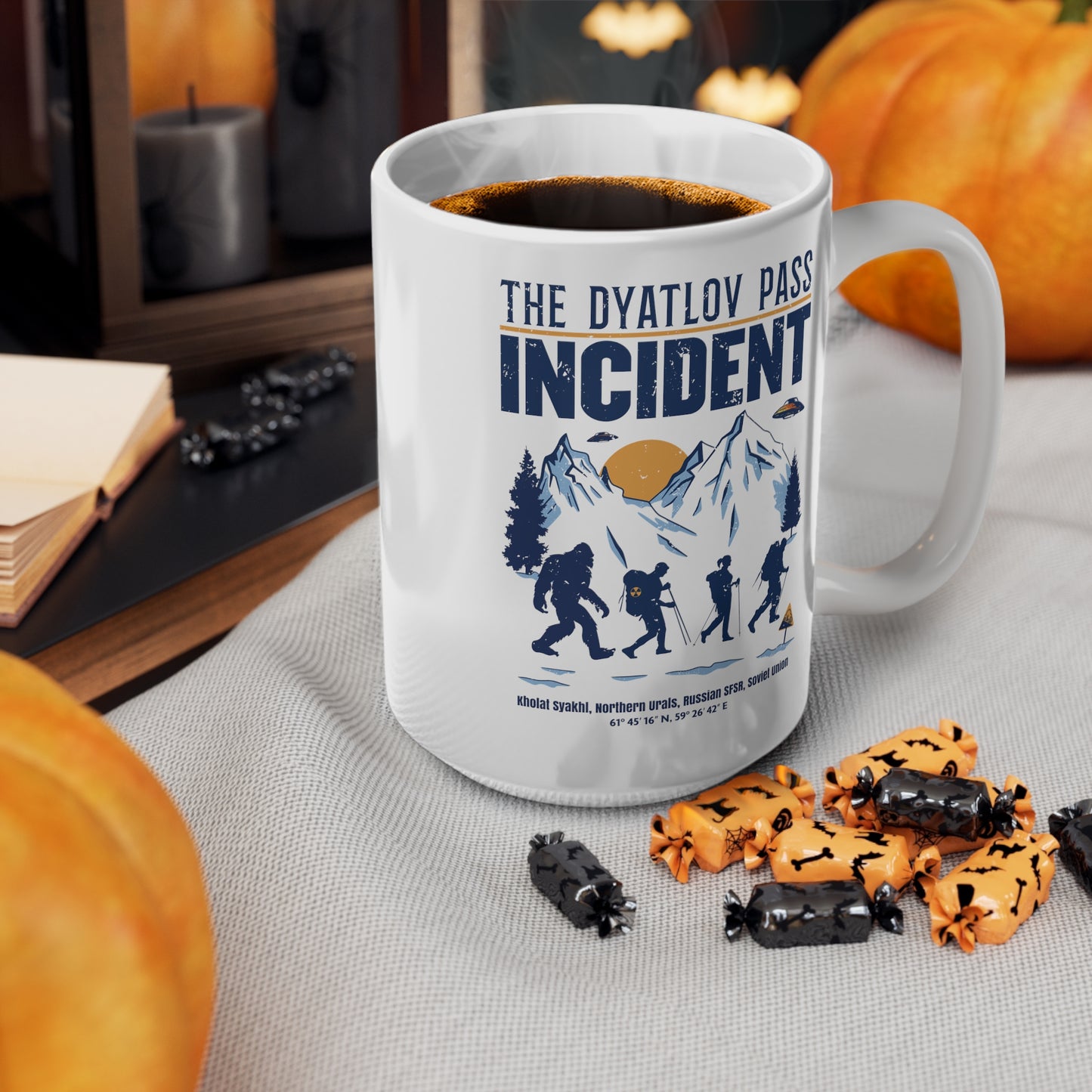 White mug of 3 hikers including Bigfoot in snowy mountains with UFOs and text THE DYATLOV PASS INCIDENT.