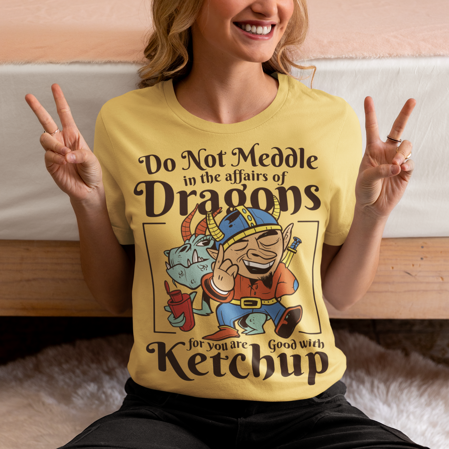 Introducing our whimsically fierce and flavorful "Dragon Connoisseur" T-shirt! This eye-catching design features a majestic dragon with a mischievous grin, proudly holding a bottle of ketchup, standing ominously behind a brave Viking. The caption, "DO NOT MEDDLE IN THE AFFAIRS OF DRAGONS FOR YOU ARE GOOD WITH KETCHUP," adds a touch of humor and a warning to all who dare to challenge the fiery and saucy taste preferences of these mythical creatures.