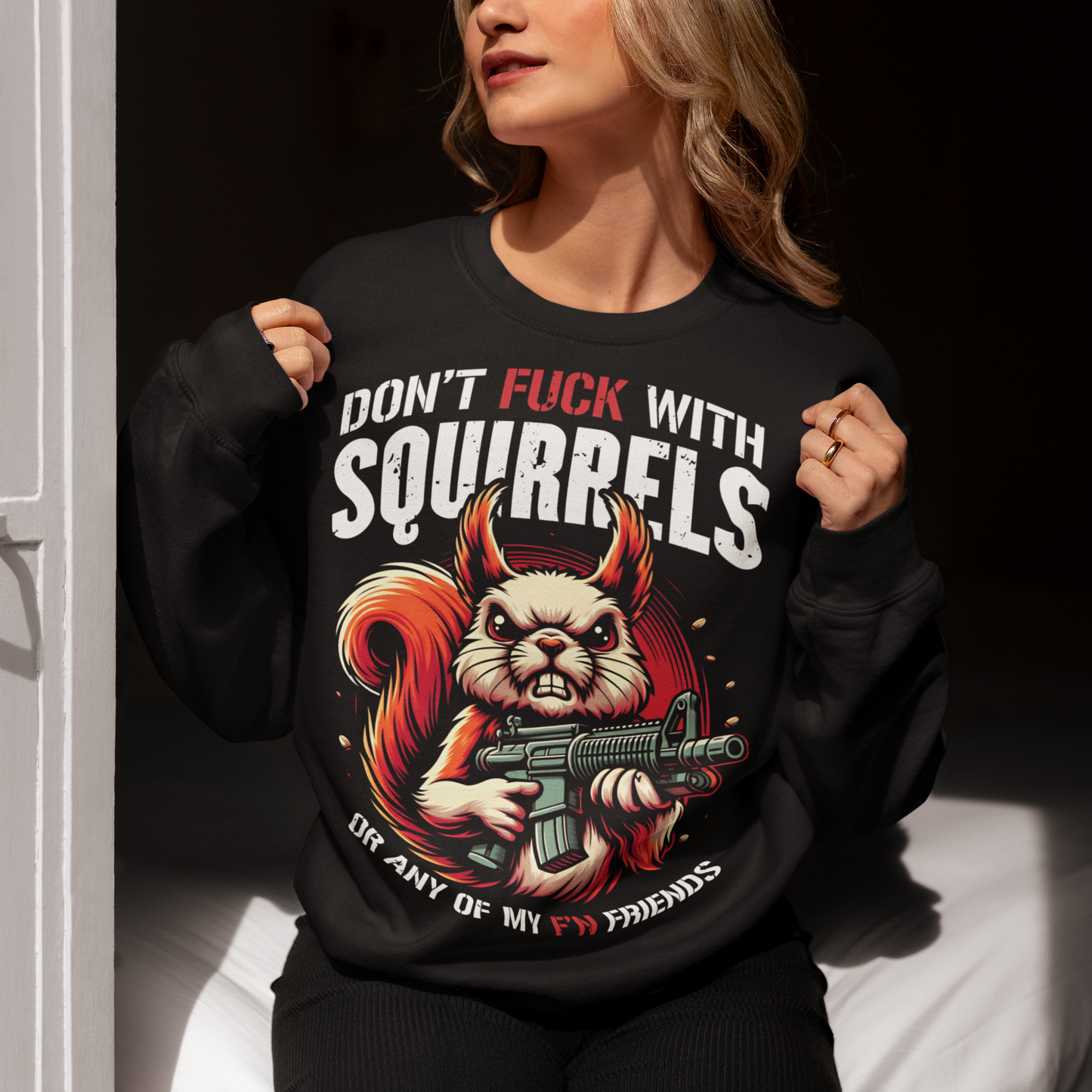 Black sweatshirt of a squirrel with a gun with text above "DON'T FUCK WITH SQUIRRELS" and text below "OR ANY OF MY F'N FRIENDS".