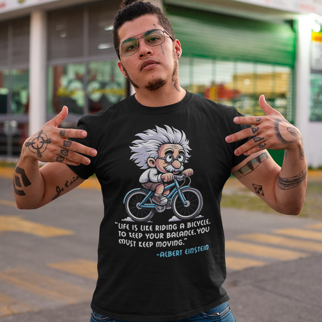 Discover the perfect blend of intellect and inspiration with our "Einstein Cycling" T-shirt. This unique design features the legendary physicist Albert Einstein enjoying a leisurely bike ride, embodying both his playful spirit and his profound wisdom. Below the whimsical illustration, you'll find one of Einstein's most motivational quotes: "Life is like riding a bicycle. To keep your balance, you must keep moving."