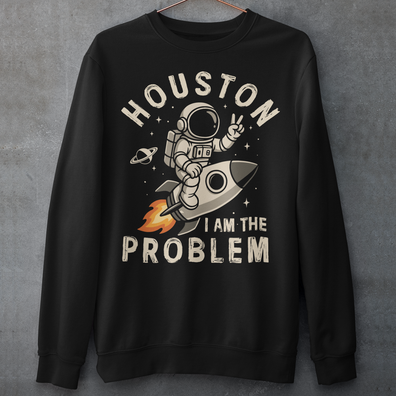 Make a statement that’s out of this world. This bold graphic sweatshirt features a fearless astronaut riding a rocket through space, throwing up a peace sign with cosmic confidence. Surrounding the design is the rebellious text: “HOUSTON I AM THE PROBLEM” — a playful twist on the classic space phrase. Perfect for space enthusiasts, rebels at heart, or anyone who loves a little cosmic humor.