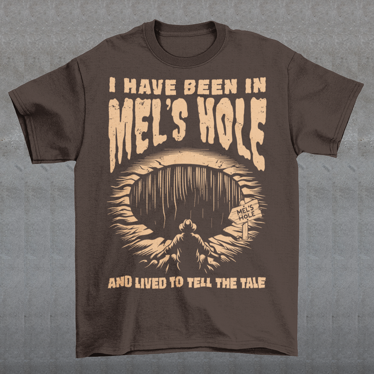 Step into the strange with this quirky and mysterious tee! Featuring a bold illustration of a curious man peering into a dark, bottomless abyss, this shirt pays homage to the legendary paranormal tale of Mel's Hole — a supposed infinite pit in the wilds of Washington State. The vintage-style artwork is topped with the eerie invitation: "VISIT MEL'S HOLE" in retro tourism font, blending humor, folklore, and a dash of the unexplained.