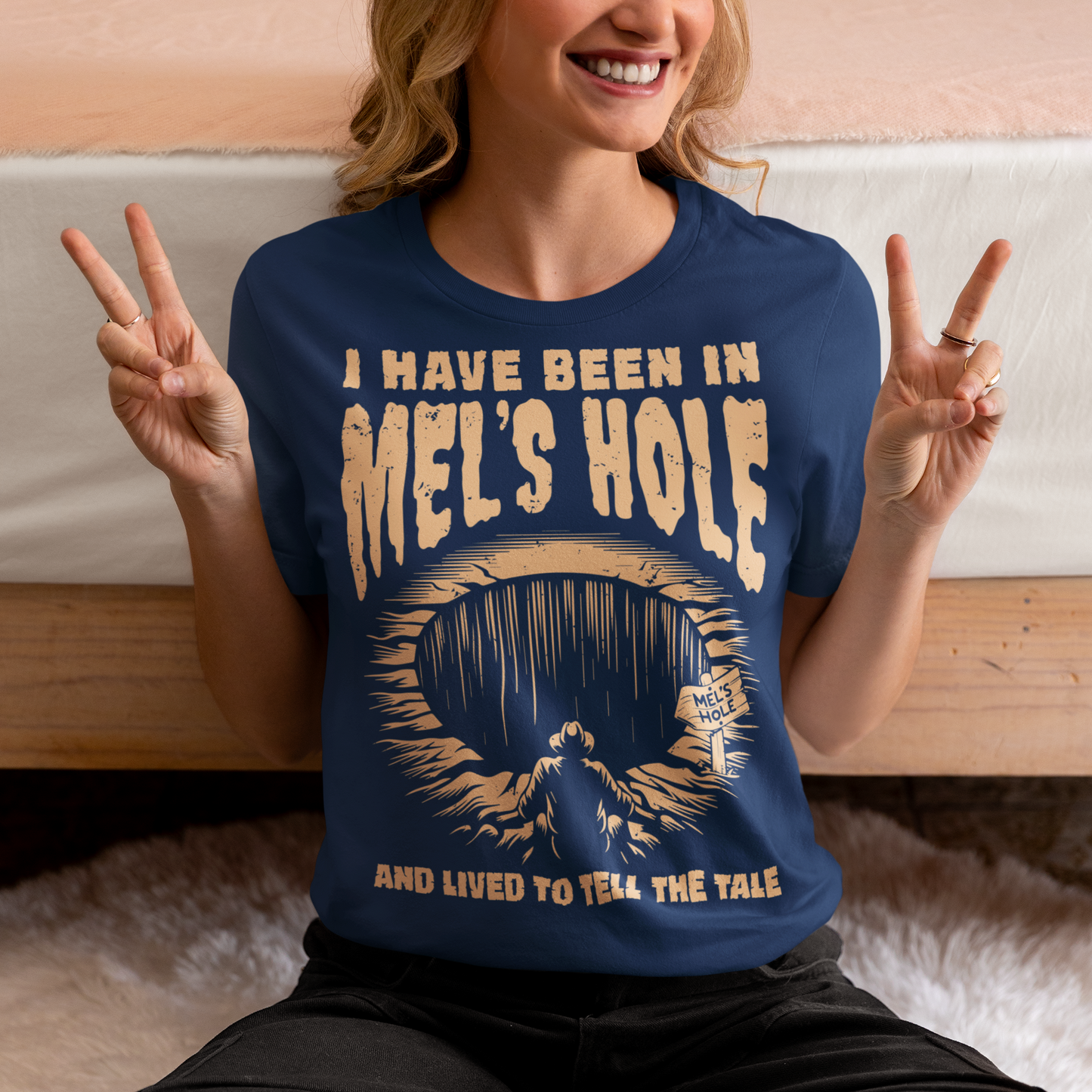 Step into the strange with this quirky and mysterious tee! Featuring a bold illustration of a curious man peering into a dark, bottomless abyss, this shirt pays homage to the legendary paranormal tale of Mel's Hole — a supposed infinite pit in the wilds of Washington State. The vintage-style artwork is topped with the eerie invitation: "VISIT MEL'S HOLE" in retro tourism font, blending humor, folklore, and a dash of the unexplained.
