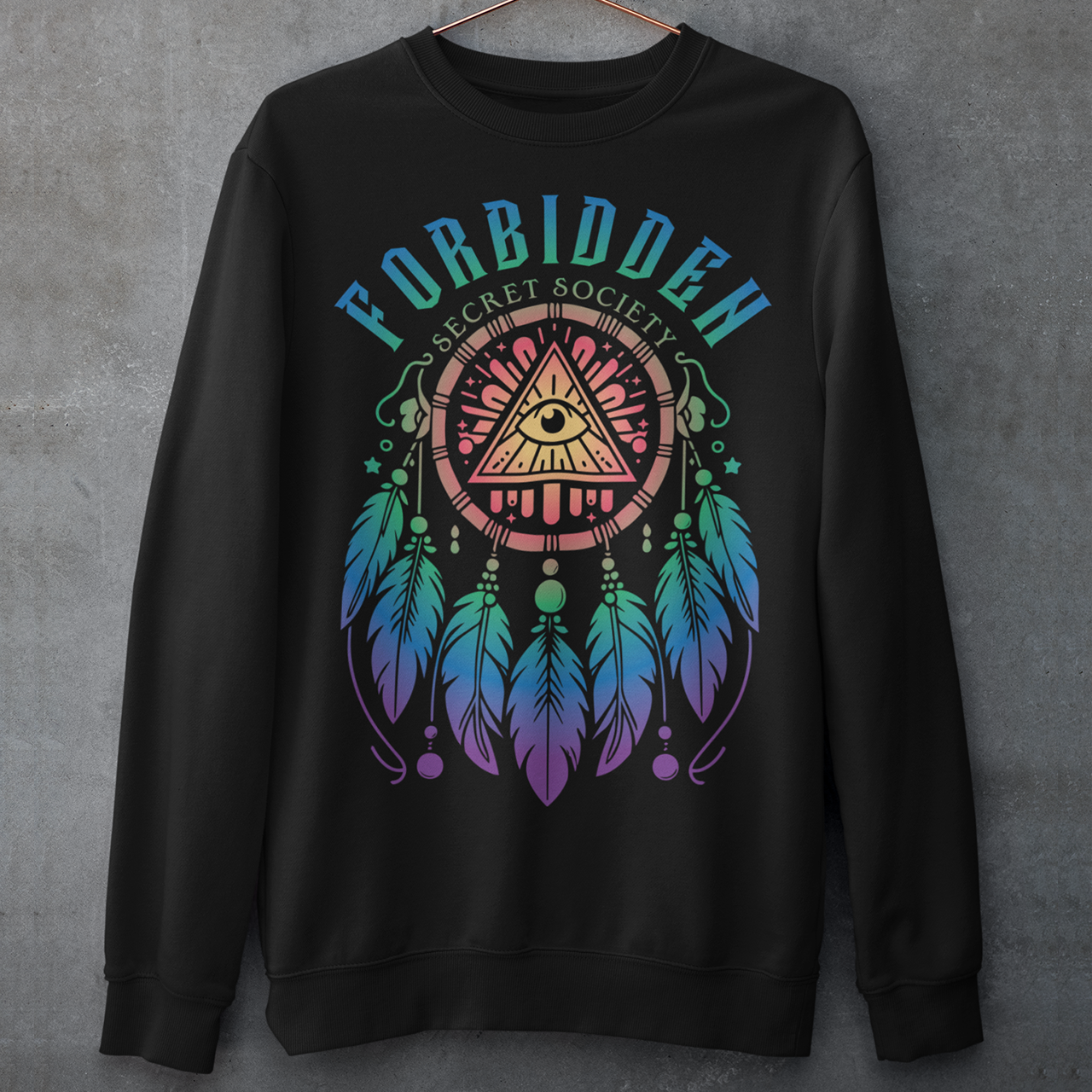 "Step into the enigmatic world of clandestine knowledge with our Illuminati Dreamcatcher sweatshirt. Featuring an intricate design that merges the mystique of the Illuminati symbol with the cultural heritage of dreamcatchers, this tee is a fusion of intrigue and symbolism. The central eye, a hallmark of Illuminati iconography, peers out from the heart of the dreamcatcher, symbolizing the pursuit of hidden truths and enlightenment.