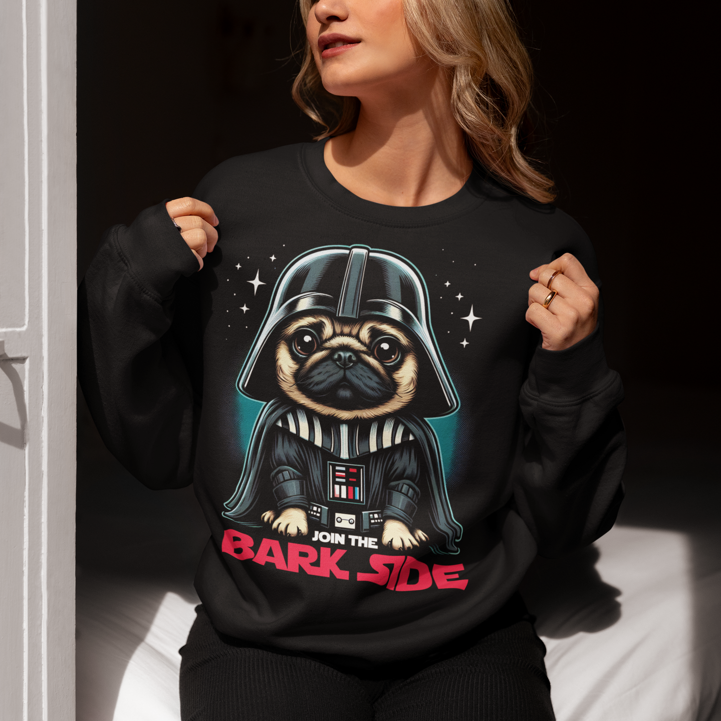 Introducing the ultimate "Join the Bark Side" Sweatshirt. This playful design features an adorable pug dressed as a Sith Lord and a determined, yet undeniably cute, expression. The pug's wrinkled face and intense stare will make anyone smile, as he embodies the dark side in the most charming way possible. Beneath the pug, bold text reads "JOIN THE BARK SIDE," adding a humorous twist to the classic phrase. This shirt is sure to be a hit for those with a love for pups and galactic adventures!