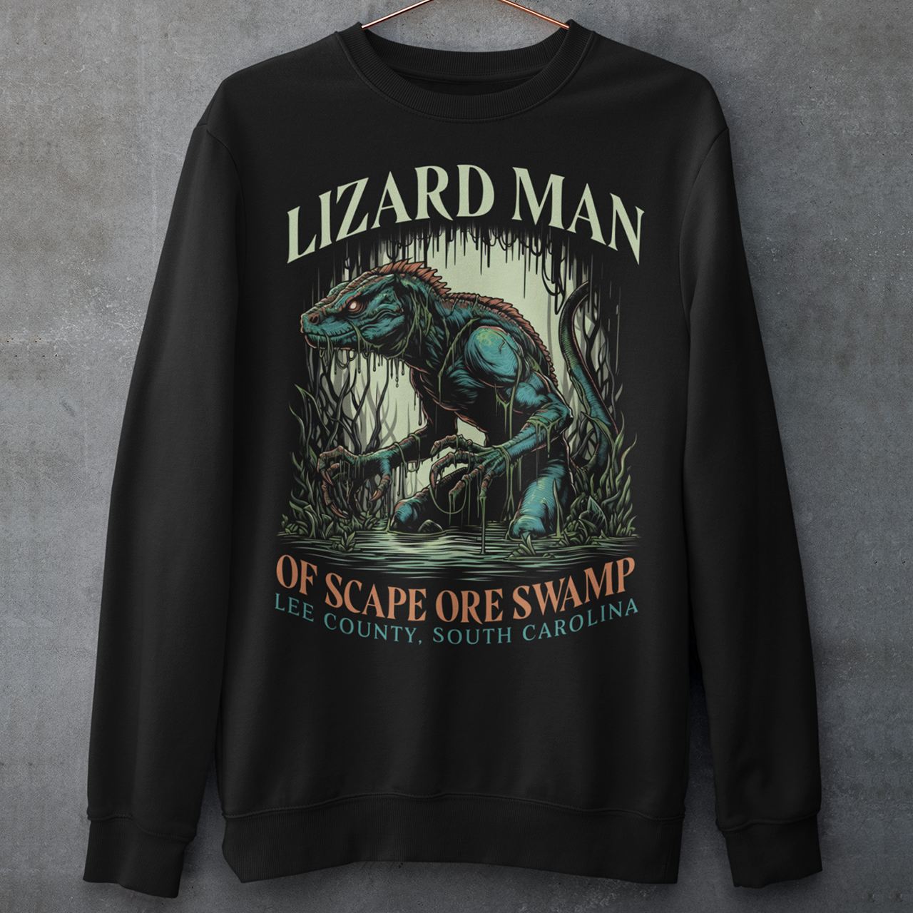 This sweatshirt features a striking design of the legendary "Lizard Man of Scape Ore Swamp." The centerpiece is a menacing yet intriguing lizard man emerging from the murky depths of a swamp, with reptilian scales glistening under the eerie moonlight. The creature's glowing yellow eyes peer out from beneath a rugged brow, and its powerful claws grasp at the twisted roots and moss that surround it.