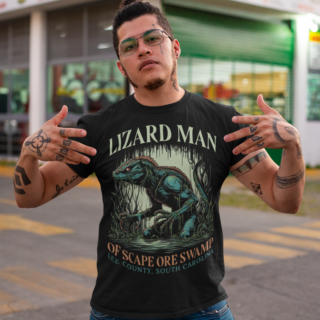 This t-shirt features a striking design of the legendary "Lizard Man of Scape Ore Swamp." The centerpiece is a menacing yet intriguing lizard man emerging from the murky depths of a swamp, with reptilian scales glistening under the eerie moonlight. The creature's glowing yellow eyes peer out from beneath a rugged brow, and its powerful claws grasp at the twisted roots and moss that surround it. Perfect for fans of cryptozoology, folklore, or anyone who loves a good monster tale!