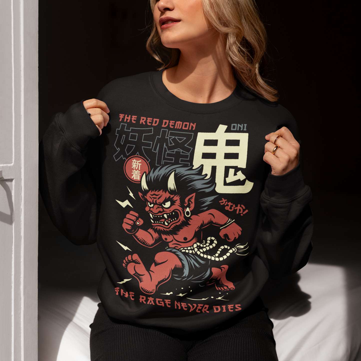 Bold, fierce, and unstoppable — this dynamic sweatshirt features a powerful Japanese Oni mid-sprint, eyes blazing and muscles tense with fury. Above the image, bold text declares "THE RED DEMON", while below, a chilling reminder reads: "THE RAGE NEVER DIES". This shirt captures the raw energy and mythic wrath of the Oni spirit — perfect for those who embrace intensity and never back down.