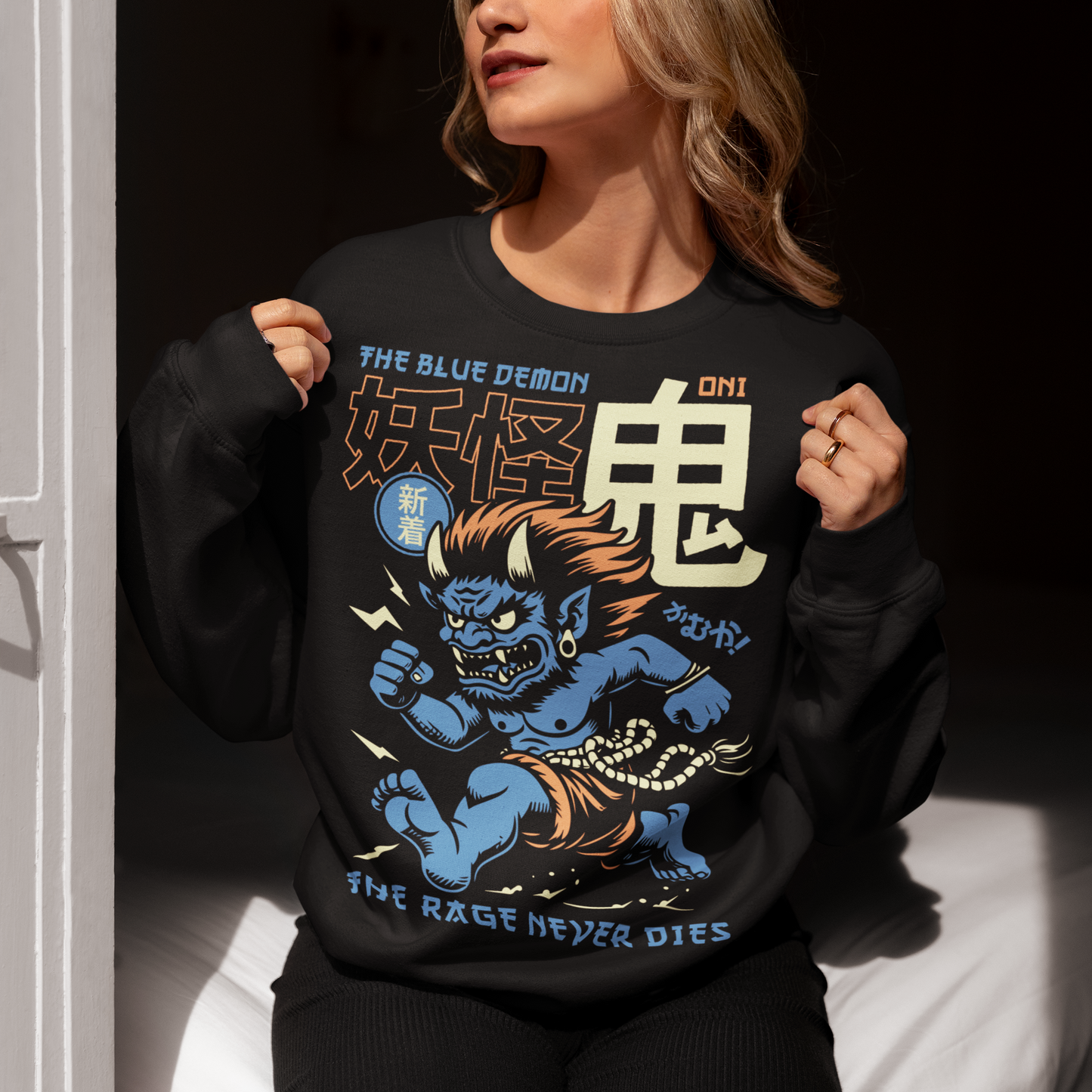 Bold, fierce, and unstoppable — this dynamic sweatshirt features a powerful Japanese Oni mid-sprint, eyes blazing and muscles tense with fury. Above the image, bold text declares "THE BLUE DEMON", while below, a chilling reminder reads: "THE RAGE NEVER DIES". This shirt captures the raw energy and mythic wrath of the Oni spirit — perfect for those who embrace intensity and never back down.