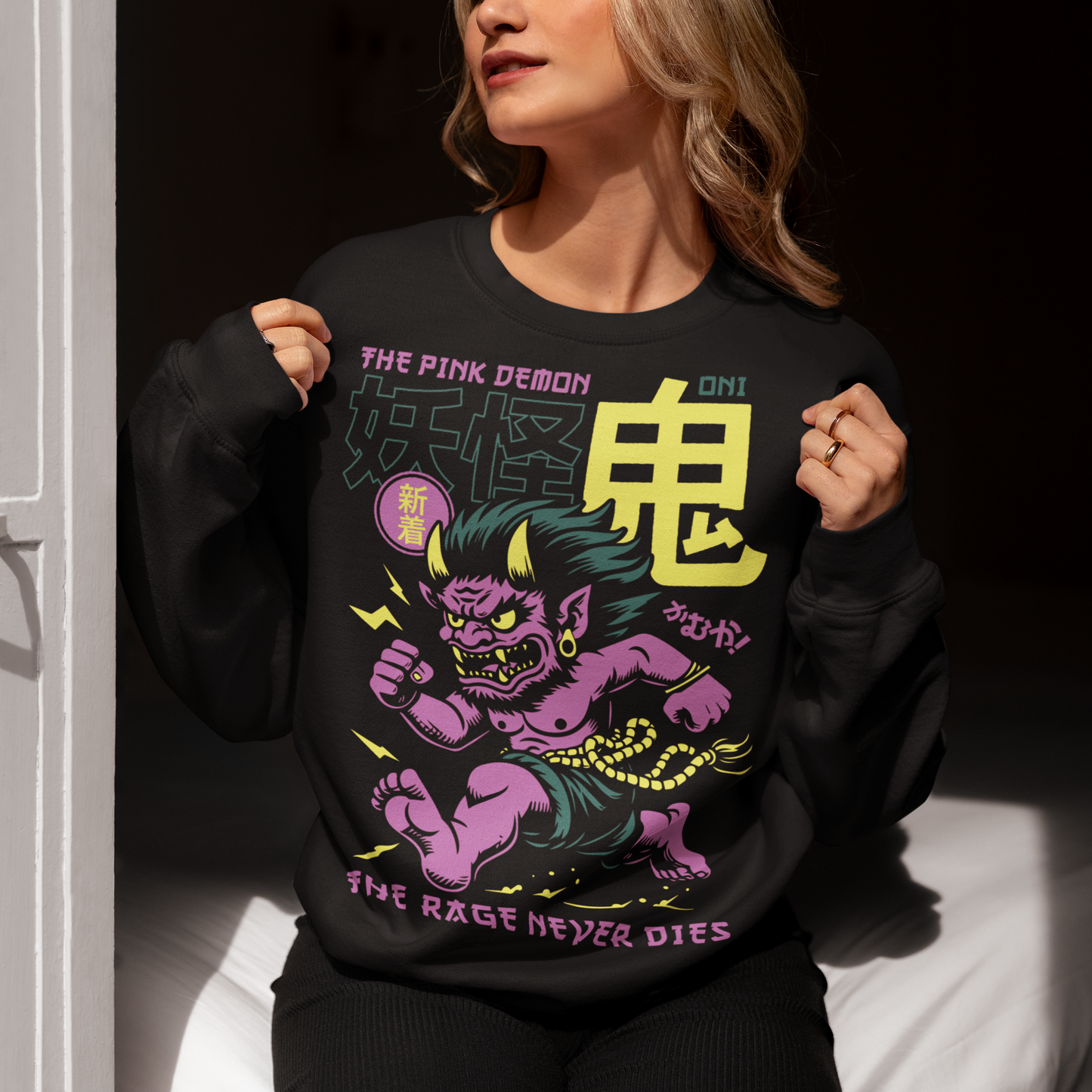 Bold, fierce, and unstoppable — this dynamic sweatshirt features a powerful Japanese Oni mid-sprint, eyes blazing and muscles tense with fury. Above the image, bold text declares "THE PINK DEMON", while below, a chilling reminder reads: "THE RAGE NEVER DIES". This shirt captures the raw energy and mythic wrath of the Oni spirit — perfect for those who embrace intensity and never back down.