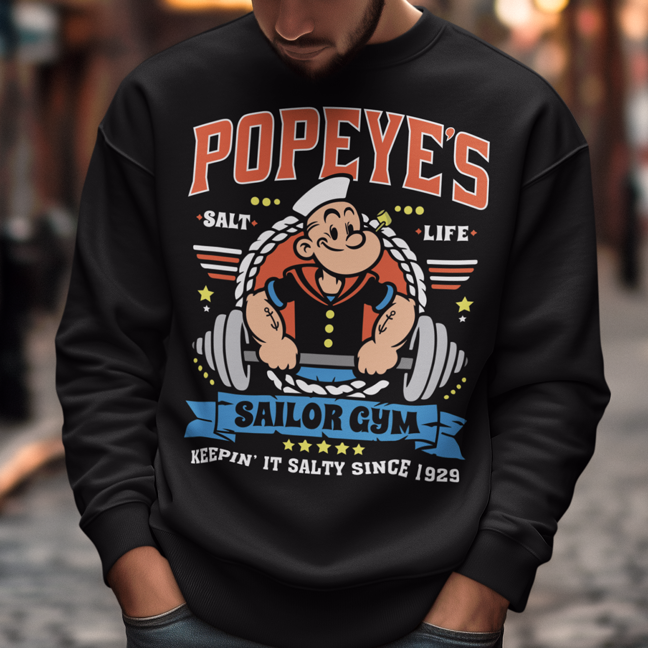 Hit the gym like a legend with the Popeye’s Sailor Gym Sweatshirt! Inspired by everyone’s favorite spinach-powered sailor, this shirt is perfect for lifting, lounging, or showing off your old-school strength. Featuring a vintage-style graphic of Popeye pumping iron with the slogan "Keepin' It Salty Since 1929", this tee brings serious muscle and serious nostalgia.