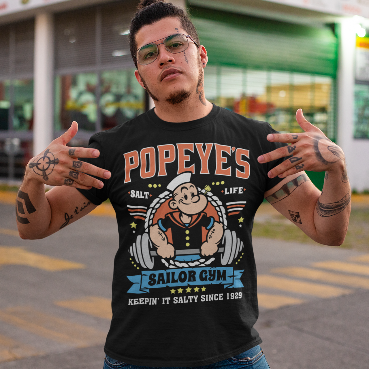 Hit the gym like a legend with the Popeye’s Sailor Gym tee! Inspired by everyone’s favorite spinach-powered sailor, this shirt is perfect for lifting, lounging, or showing off your old-school strength. Featuring a vintage-style graphic of Popeye pumping iron with the slogan "Keepin' It Salty Since 1929", this tee brings serious muscle and serious nostalgia.