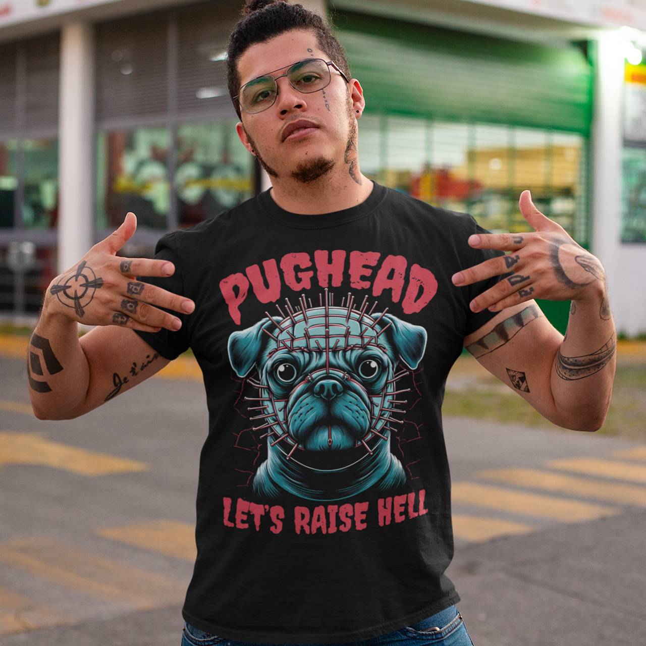 This t-shirt features a bold and playful design, perfect for pug lovers with a dark sense of humor! The central image showcases a tough-looking pug with pins in his head, a quirky nod to horror and punk aesthetics. Above the pug, the text "PUGHEAD" is written in a sharp, edgy font, while below, the phrase "LET'S RAISE HELL" completes the rebellious vibe.