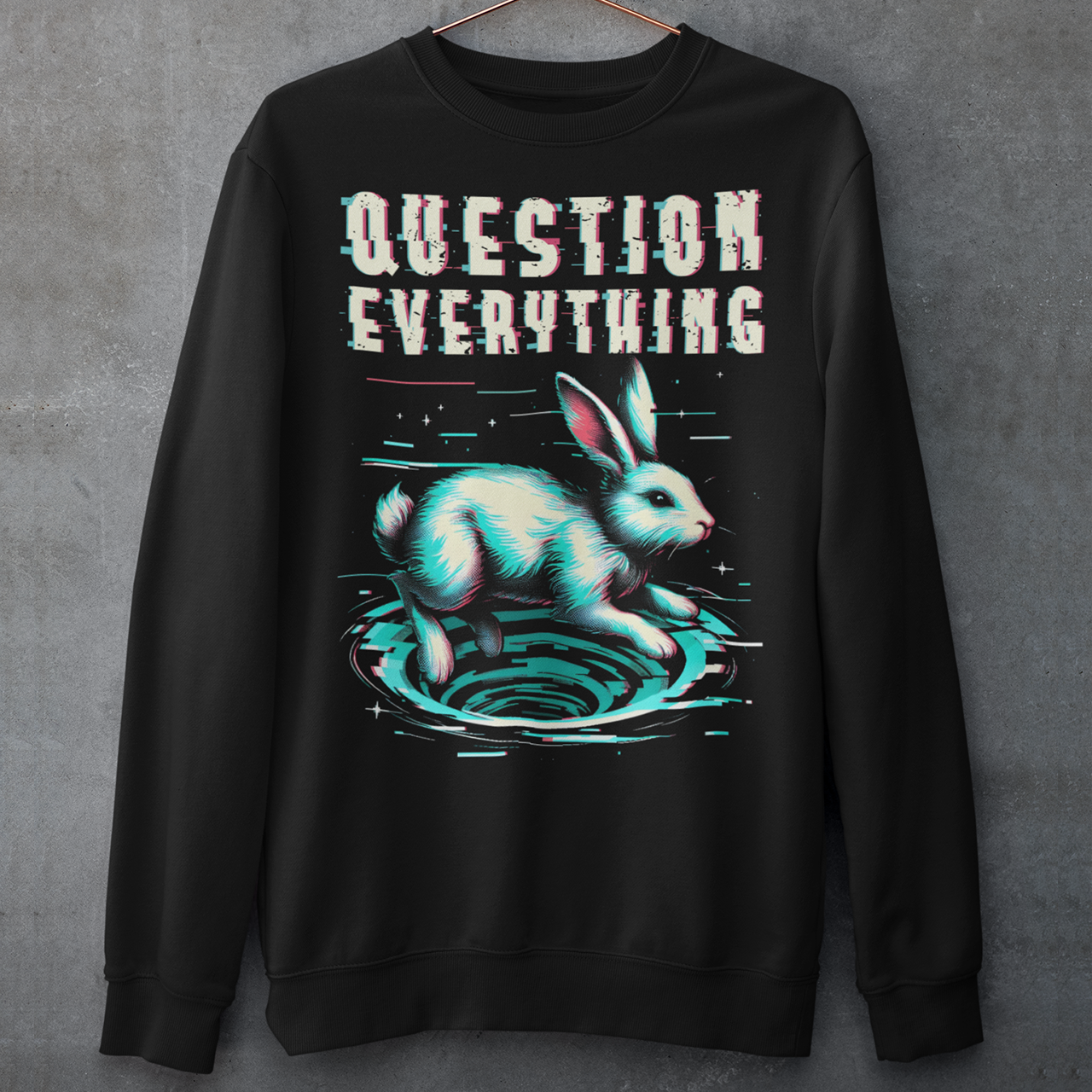A graphic sweatshirt featuring a stylized illustration of a white rabbit diving headfirst into a swirling rabbit hole. The rabbit's legs and tail are visible as it disappears into the tunnel, surrounded by abstract, distorted digital effects. Above the image, the phrase "QUESTION EVERYTHING" appears in bold, glitched typography, as if corrupted or scrambled, adding a sense of mystery and rebellion. The design evokes curiosity and themes of exploration and truth-seeking.