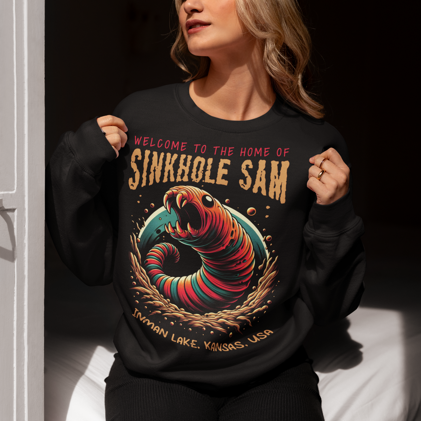Unleash your inner cryptid enthusiast with our exclusive Sinkhole Sam Sweatshirt! This shirt features a bold, vibrant graphic of the legendary creature from Kansas folklore, brought to life in stunning detail. Sinkhole Sam, the elusive serpent-like beast rumored to inhabit the deep waters of Inman Lake, is depicted in a dramatic, eye-catching design that captures the mystery and excitement of this local legend.