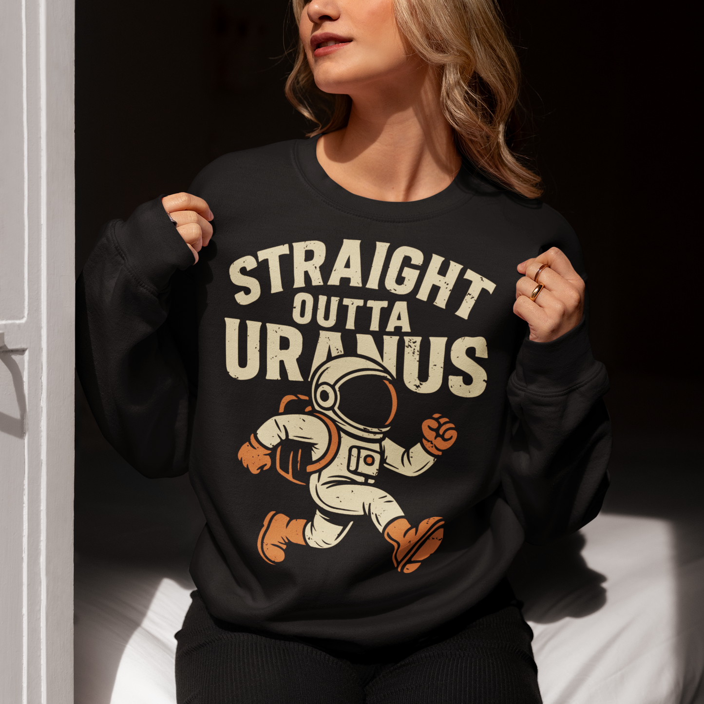 Make the galaxy laugh with this bold and hilarious sweatshirt! Featuring a cartoon-style spaceman floating in the cosmos, this shirt makes a cosmic statement with the cheeky slogan "STRAIGHT OUTTA URANUS" printed above. Perfect for space nerds, pun-lovers, and anyone who appreciates a little interstellar humor. Whether you’re stargazing, gaming, or just looking to get a few laughs, this shirt is guaranteed to be a conversation starter.