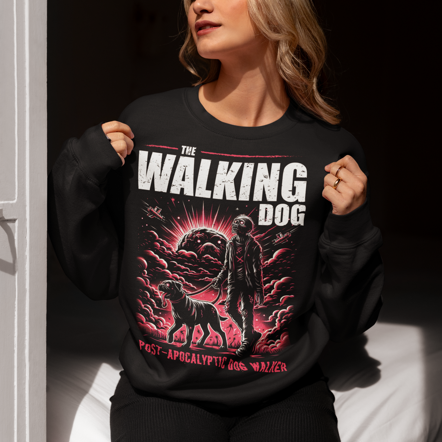 Introducing our "The Walking Dog" Sweatshirt, a unique and humorous take on the post-apocalyptic world! This eye-catching design features a determined zombie, dressed in tattered remnants of its former life, strolling through a desolate landscape with a loyal canine companion on a leash. Above this vivid illustration, the bold text "THE WALKING DOG" sets the scene, while below, the phrase "POST-APOCALYPTIC DOG WALKER" adds a touch of irony and wit.