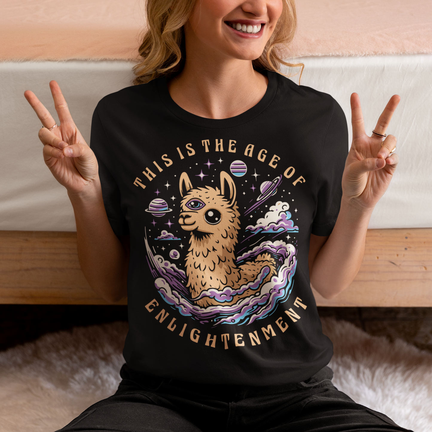 Embrace cosmic wisdom with our captivating Llama t-shirt! Picture this: amidst the vast expanse of space, a serene Llama gazes into the universe, its third eye gleaming with enlightenment. With swirling galaxies as its backdrop, this design captures the essence of transcendence and insight. Around the celestial spectacle, bold text declares, 'THIS IS THE AGE OF ENLIGHTENMENT,' heralding a new era of awareness and understanding.