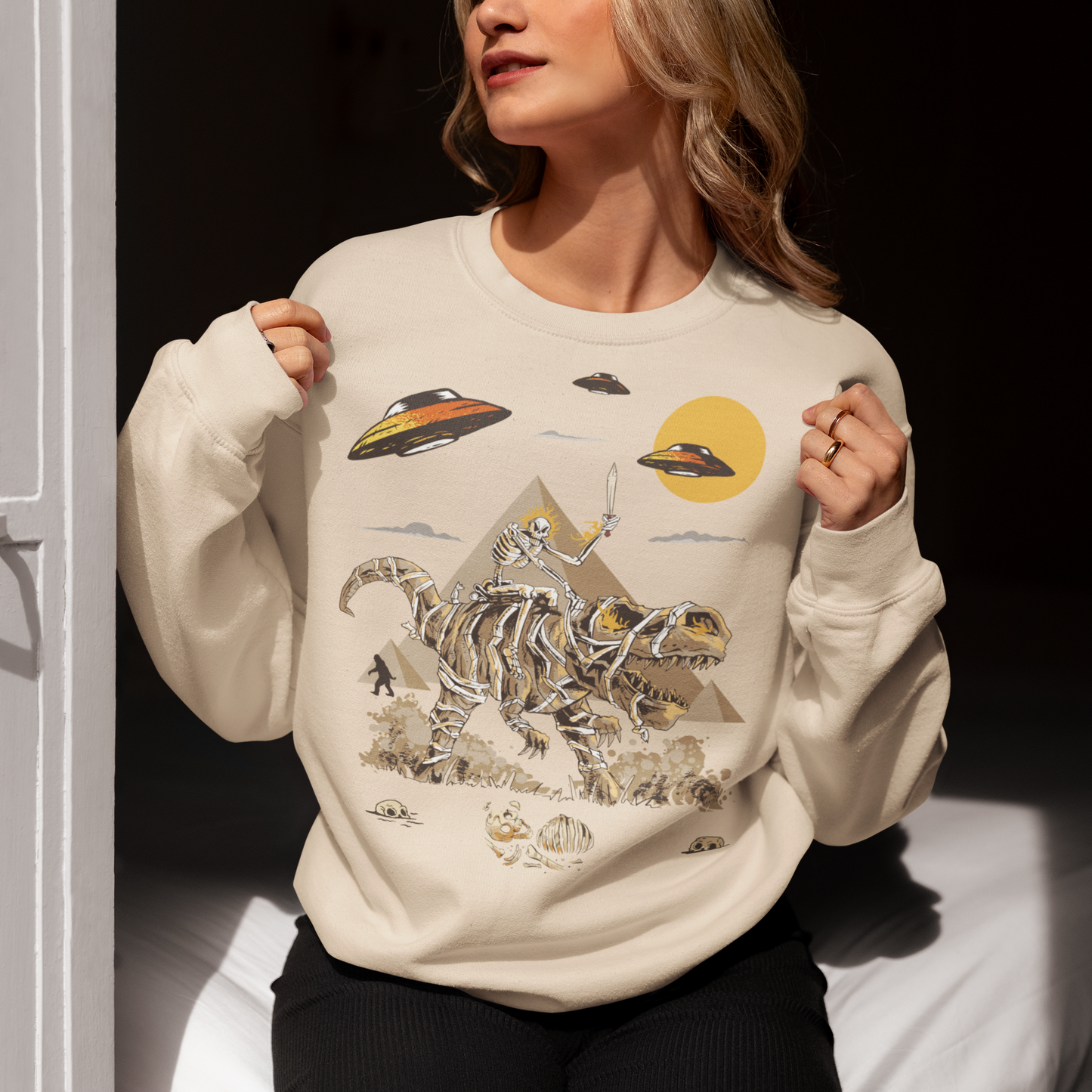 Get ready to embark on an epic adventure with our mind-blowing sweatshirt design! Picture this: a skeleton riding a T-Rex through the ancient wonders of Egypt, with UFOs hovering in the sky and Bigfoot mysteriously lurking in the background. It's a jaw-dropping fusion of history, mythology, and the unknown, all beautifully captured in one captivating design.