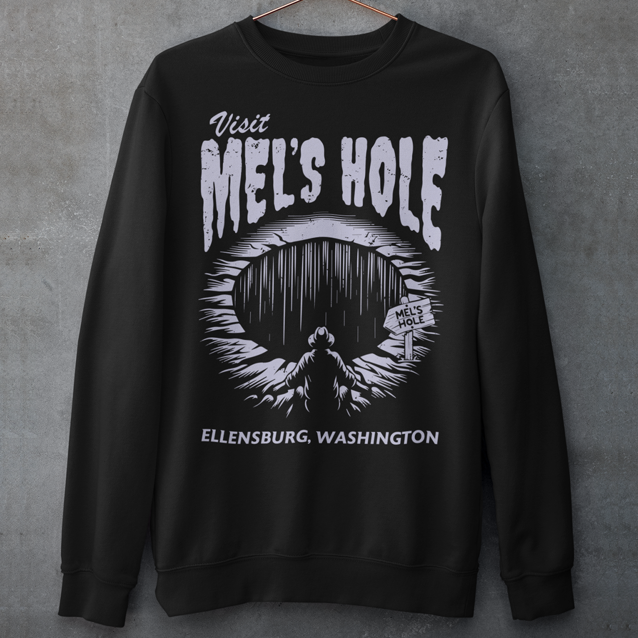 Step into the strange with this quirky and mysterious shirt! Featuring a bold illustration of a curious man peering into a dark, bottomless abyss, this shirt pays homage to the legendary paranormal tale of Mel's Hole — a supposed infinite pit in the wilds of Washington State. The vintage-style artwork is topped with the eerie invitation: "VISIT MEL'S HOLE" in retro tourism font, blending humor, folklore, and a dash of the unexplained.