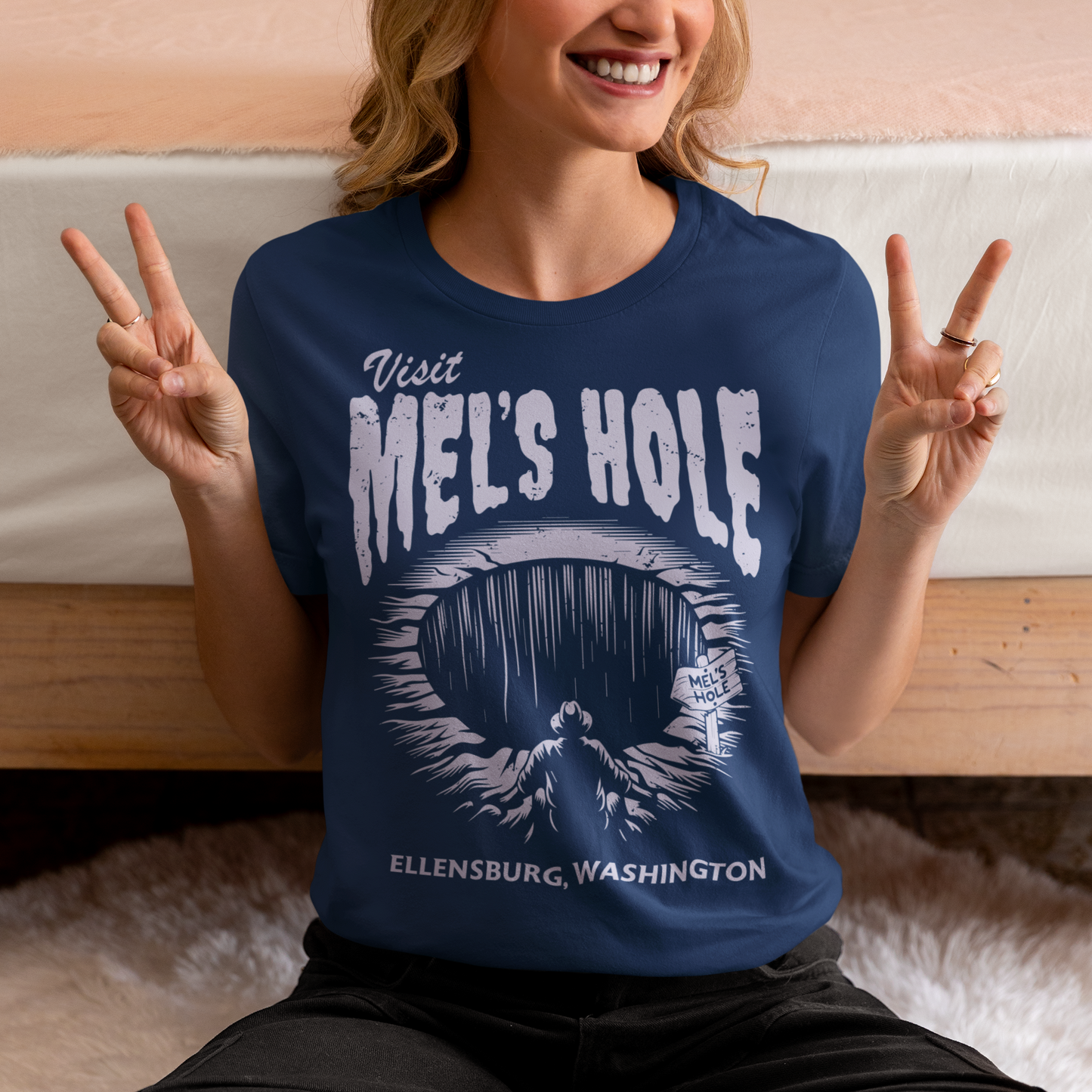 Step into the strange with this quirky and mysterious tee! Featuring a bold illustration of a curious man peering into a dark, bottomless abyss, this shirt pays homage to the legendary paranormal tale of Mel's Hole — a supposed infinite pit in the wilds of Washington State. The vintage-style artwork is topped with the eerie invitation: "VISIT MEL'S HOLE" in retro tourism font, blending humor, folklore, and a dash of the unexplained.