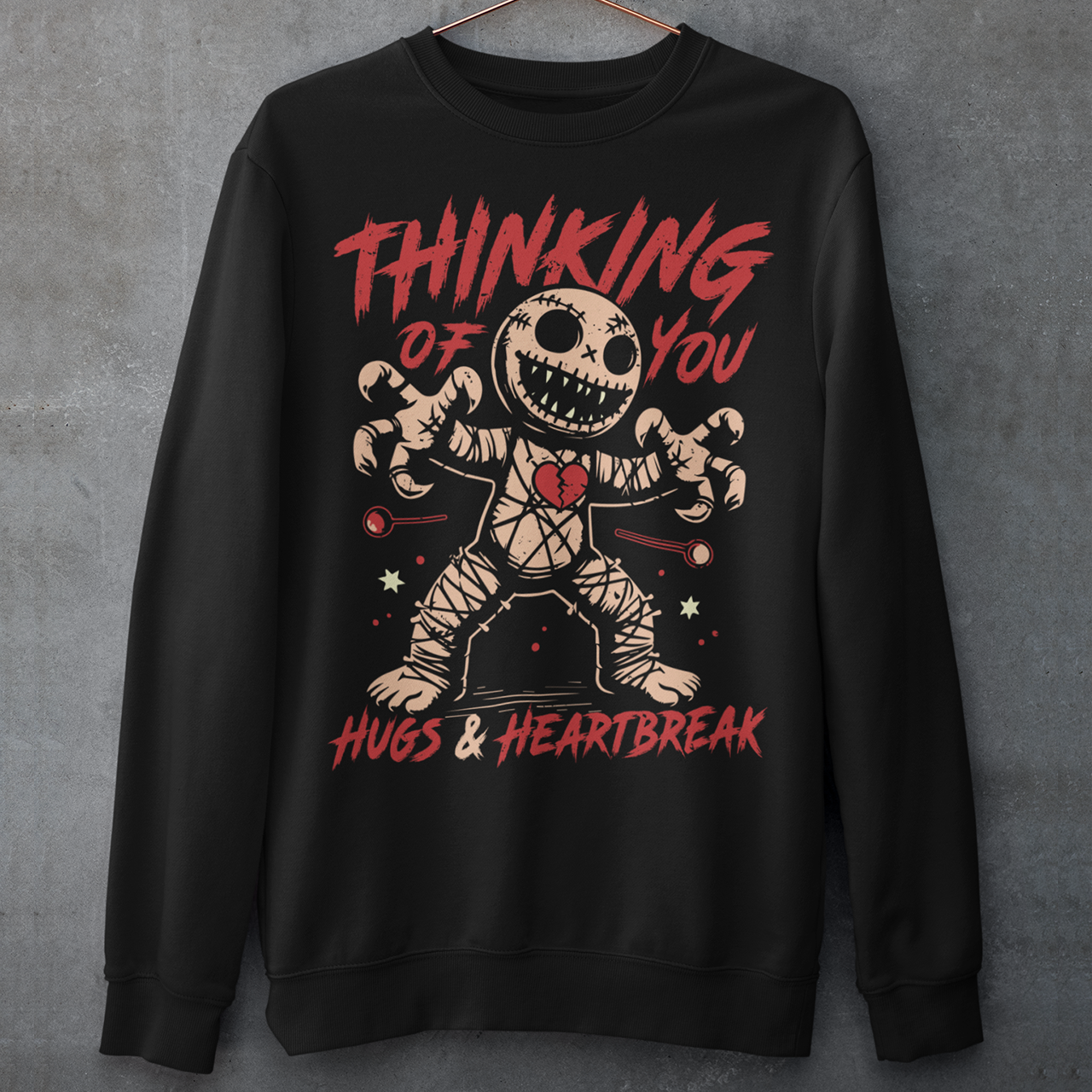 Dark humor meets twisted sweetness with this bold sweatshirt. Featuring a stitched-up voodoo doll at the center, the design captures that perfect mix of love and pain. Above the doll, the phrase “THINKING OF YOU” adds a playful sting, while below, “HUGS & HEARTBREAK” ties it all together with equal parts irony and affection. Perfect for anyone who loves edgy, alternative fashion—or just wants to send a cheeky message without saying a word.