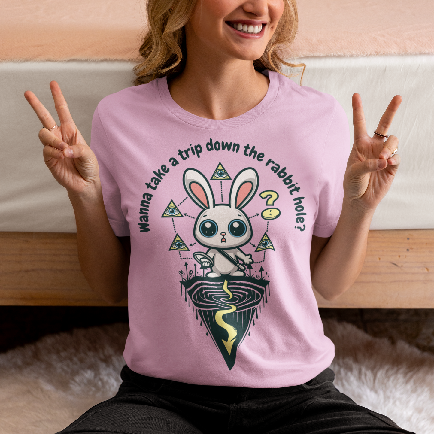 Introducing our one-of-a-kind t-shirt design that's sure to turn heads and spark conversations wherever you go! Picture this: a mysterious rabbit, with an enigmatic glint in its eye, standing poised at the entrance of a deep rabbit hole. Its ears perked up, as if listening for secrets only it knows. Above this captivating scene, bold text reads: "WANNA TAKE A TRIP DOWN THE RABBIT HOLE." Embrace your inner conspiracy theorist and invite others to join you on a journey into the unknown.