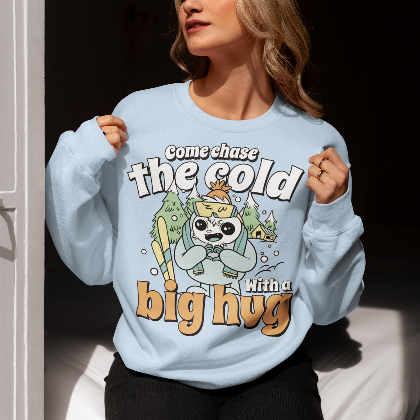 Hit the slopes in style with this playful Yeti Skiing sweatshirt! Featuring a whimsical illustration of a friendly yeti standing in the snow, this design pairs perfectly with the cozy, heartwarming message: "Come chase the cold with a big hug." Whether you're a winter sports enthusiast or just love mythical creatures with a soft side, this tee wraps comfort, humor, and chill vibes into one awesome package.