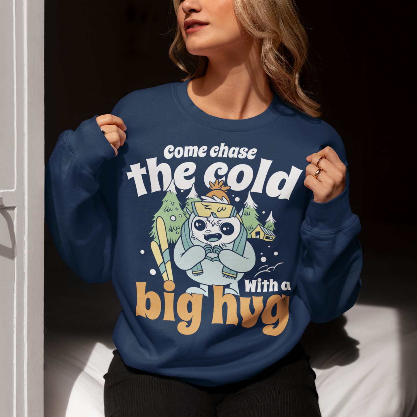Hit the slopes in style with this playful Yeti Skiing sweatshirt! Featuring a whimsical illustration of a friendly yeti standing in the snow, this design pairs perfectly with the cozy, heartwarming message: "Come chase the cold with a big hug." Whether you're a winter sports enthusiast or just love mythical creatures with a soft side, this tee wraps comfort, humor, and chill vibes into one awesome package.