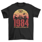 A black t-shirt with a design of a sunset with dystopian silhouette with text underneath "1984 BIG BROTHER IS WATCHING".