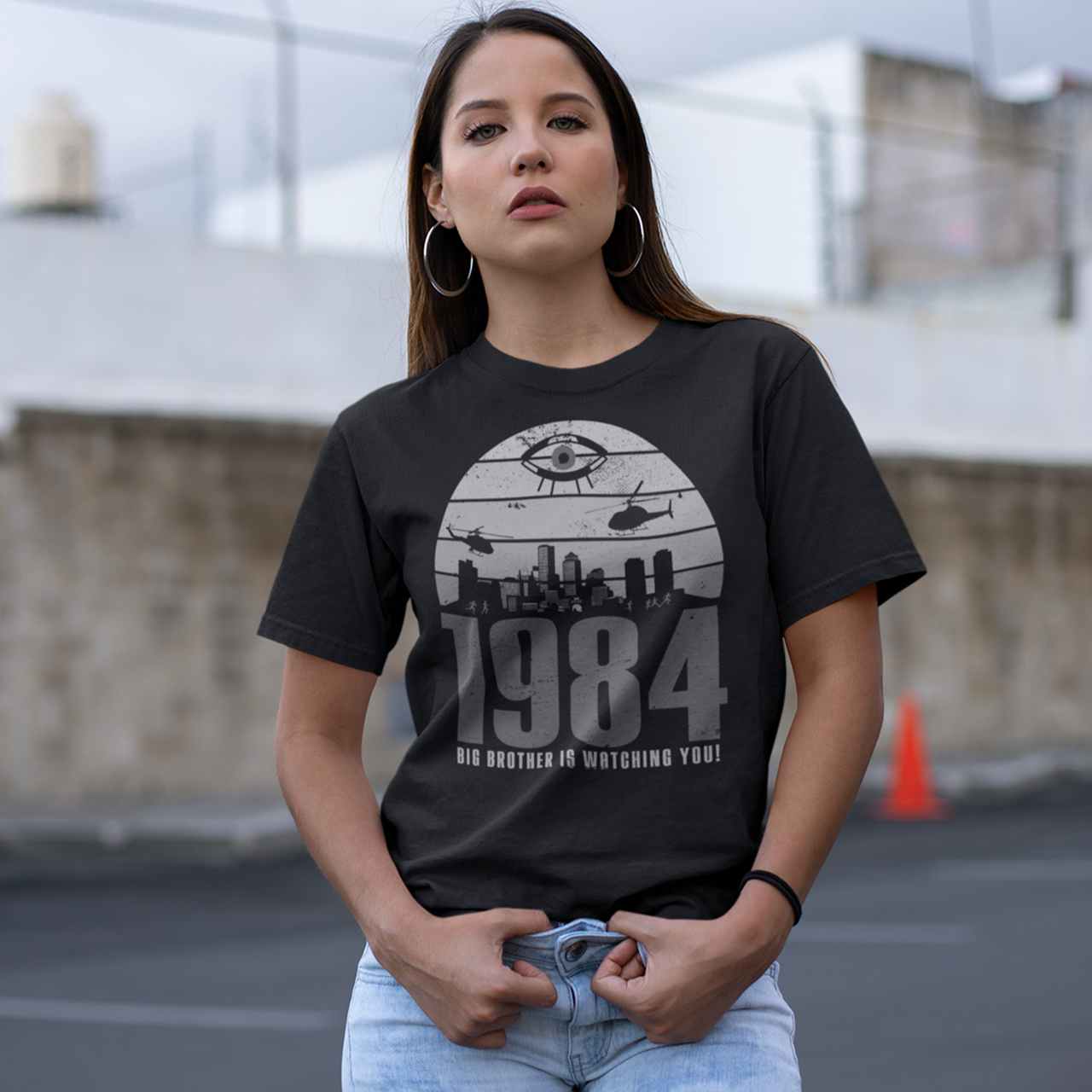 A black t-shirt with a design of a sunset with dystopian silhouette with text underneath "1984 BIG BROTHER IS WATCHING".