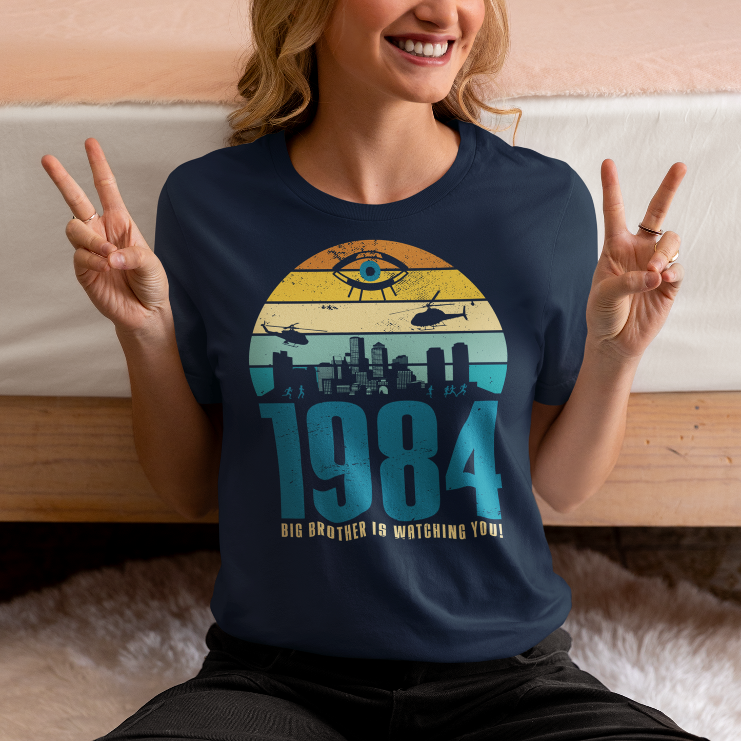 A navy t-shirt with a design of a sunset with dystopian silhouette with text underneath "1984 BIG BROTHER IS WATCHING".