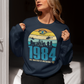 Navy sweatshirt of a dystopian city silhouette on a retro sun with text 1984 BIG BROTHER IS WATCHING YOU!