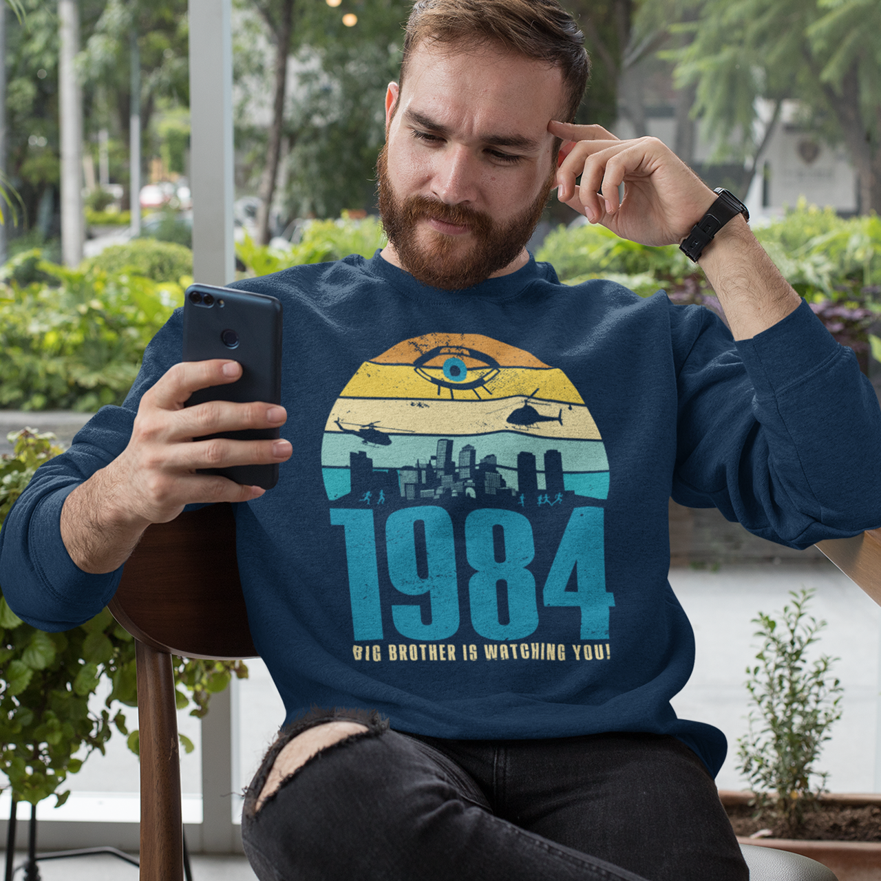 Navy sweatshirt of a dystopian city silhouette on a retro sun with text 1984 BIG BROTHER IS WATCHING YOU!