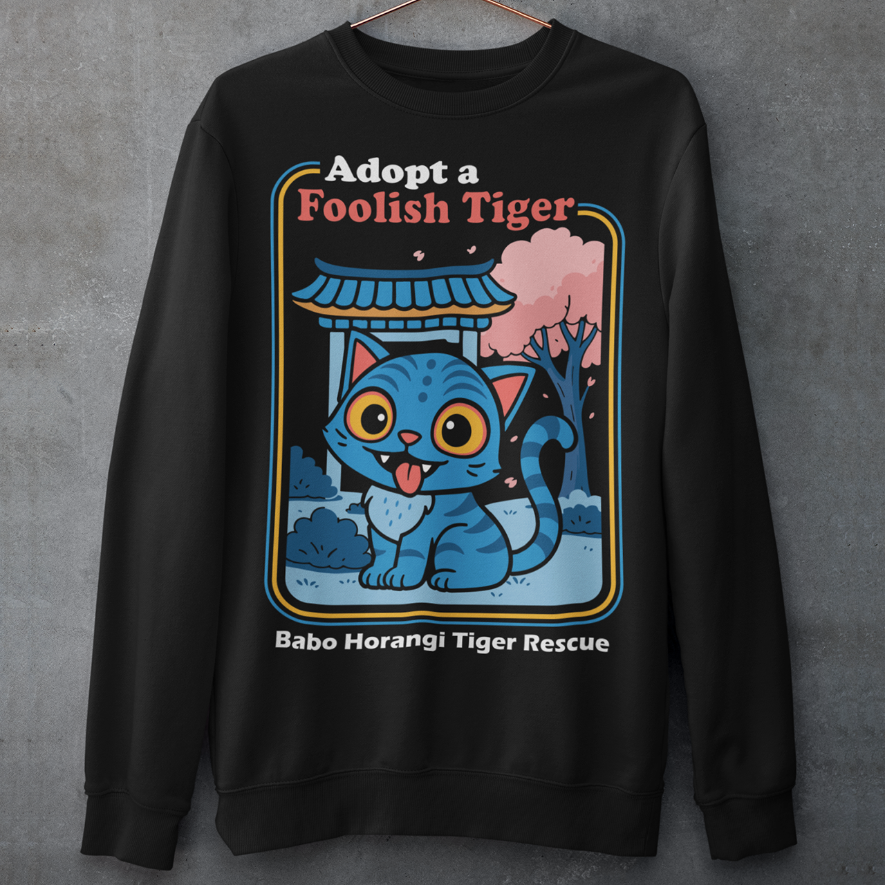 Adopt a foolish tiger t-shirt. Derpy kpop demon hunters shirt. Babo Horangi tee. This design feels like a Korean folklore creature wandered into a Saturday morning cartoon and decided to stay for snacks. A wide eyed blue “foolish tiger” sits under a temple gate with cherry blossoms drifting by, tongue out, zero survival instincts, maximum charm. The playful mix of myth inspired setting and goofy expression makes it equal parts legend and lovable disaster.on hunters shirt.