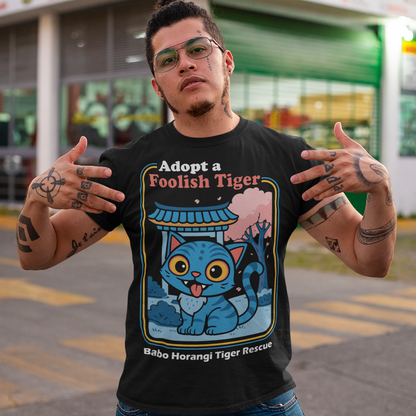 Adopt a foolish tiger t-shirt. Derpy kpop demon hunters shirt. Babo Horangi tee. This design feels like a Korean folklore creature wandered into a Saturday morning cartoon and decided to stay for snacks. A wide eyed blue “foolish tiger” sits under a temple gate with cherry blossoms drifting by, tongue out, zero survival instincts, maximum charm. The playful mix of myth inspired setting and goofy expression makes it equal parts legend and lovable disaster.on hunters shirt.