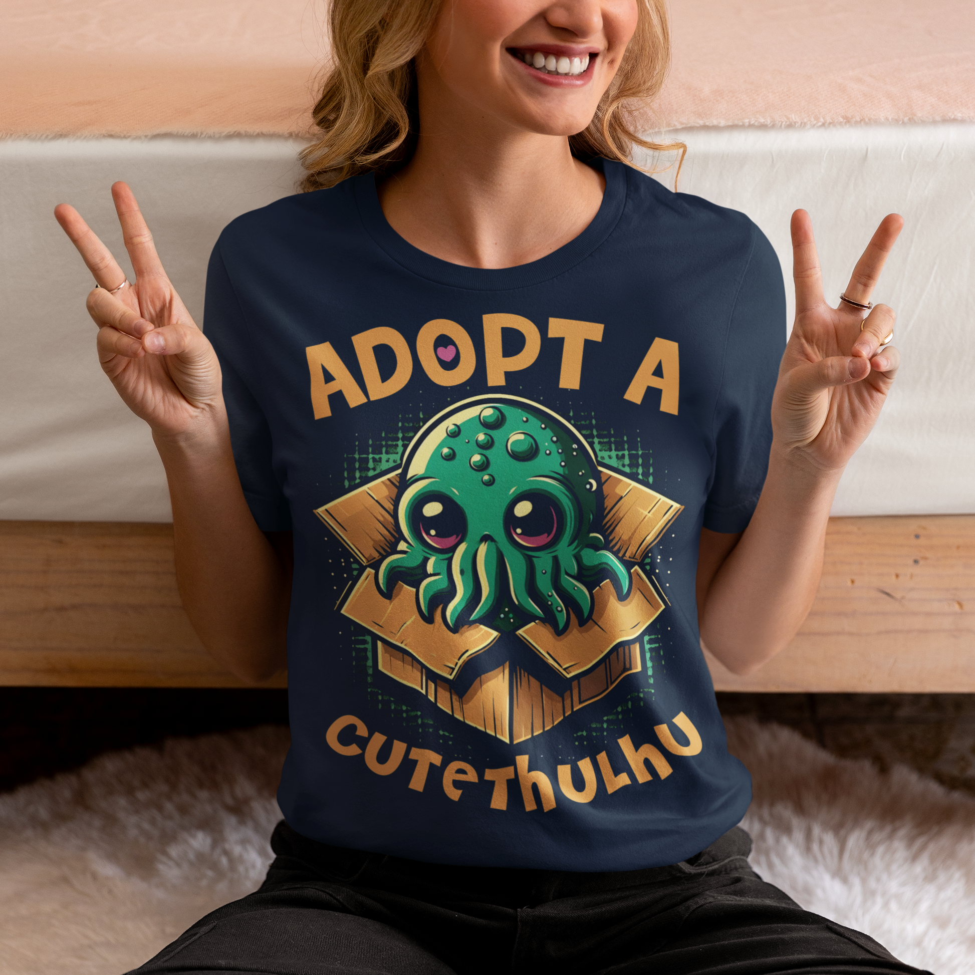 Navy t-shirt of a cute Cthulhu in a cardboard box with text ADOPT A CUTETHULHU.