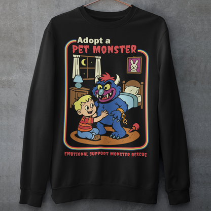Soft, spooky, and suspiciously adorable, this sweatshirt looks like it came straight from a slightly haunted Saturday morning cartoon vault. The design features a wide eyed kid befriending a fuzzy little monster with tiny horns and big attitude, all set inside a cozy bedroom scene with retro storybook vibes. The bold “Adopt a Pet Monster” headline and “Emotional Support Monster Rescue” tagline sell the joke perfectly, blending cute chaos with feel good humor.