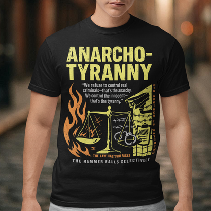 Black t-shirt featuring a distressed yellow “ANARCHO-TYRANNY” graphic with scales of justice, flames, barbed wire, surveillance imagery, and prison-themed artwork. The design includes the phrases “THE LAW HAS TWO FACES” and “THE HAMMER FALLS SELECTIVELY,” creating a bold political statement focused on authority, government power, civil liberties, and anti-authoritarian themes.