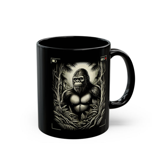 Black mug of Bigfoot being recorded looking through the trees.