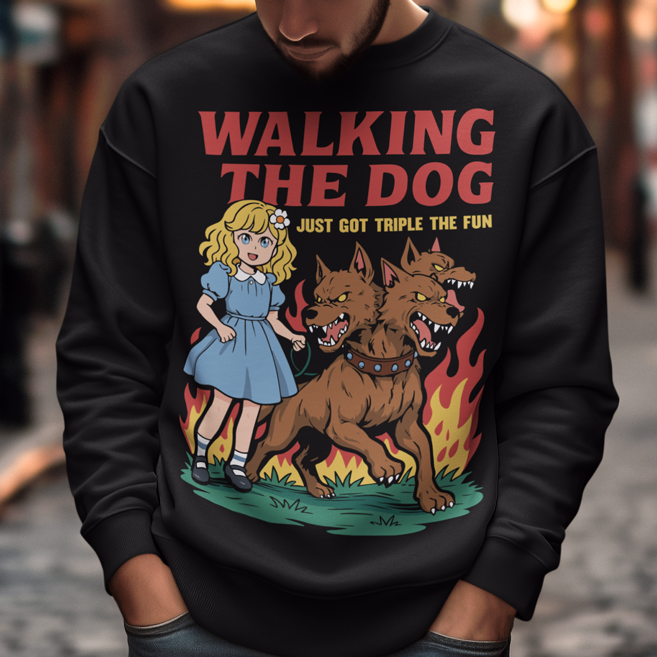 Black Sweatshirt featuring a colorful cartoon design of a young girl in a blue dress casually walking a three-headed Cerberus dog on a leash. The fierce hellhound snarls with sharp teeth while flames rise behind it, creating a striking contrast between cute and chaotic. Bold red text reads “Walking the Dog” with smaller text below saying “Just Got Triple the Fun,” adding humor to the fantasy-inspired scene.